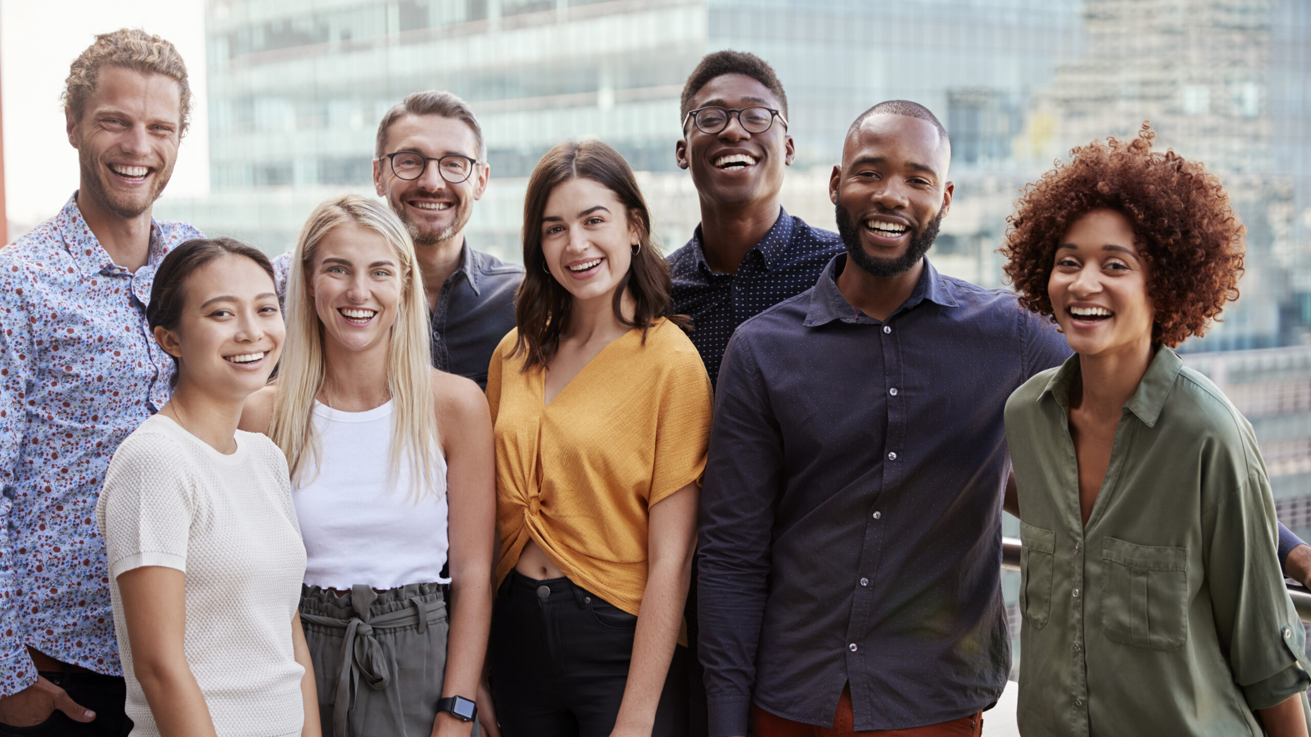 Group portrait of a creative business team standing outdoors, three quarter length, close up