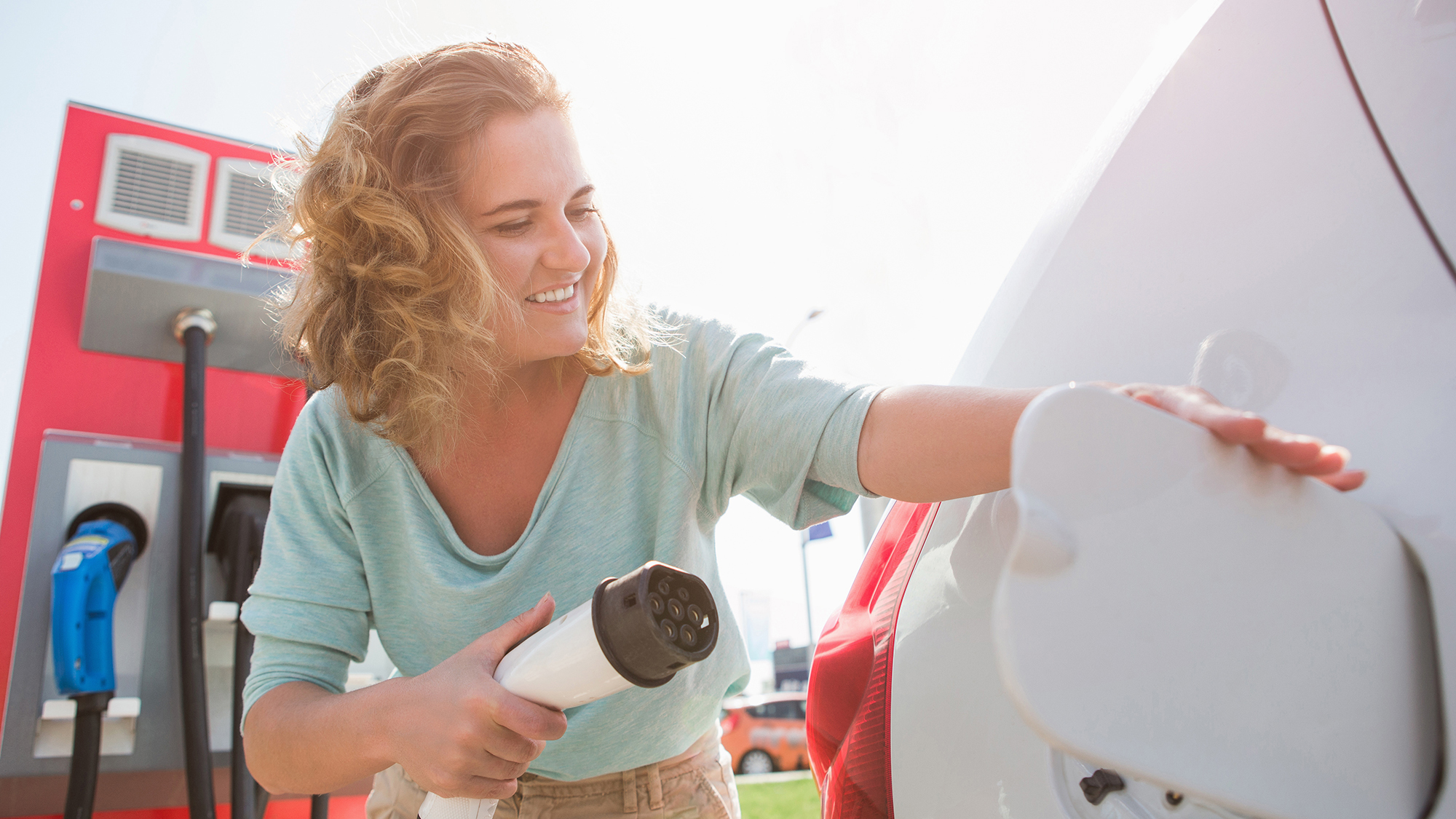 A woman at the charging station for electric vehicles