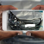 Man taking photo of his car with damages