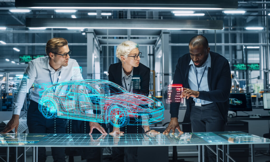 Diverse Team of Engineers Working in Office at Industrial Factory. Industrial Designers Discuss Electric Car Augmented Reality Hologramm. Specialists Work in Technological Car Development Facility.