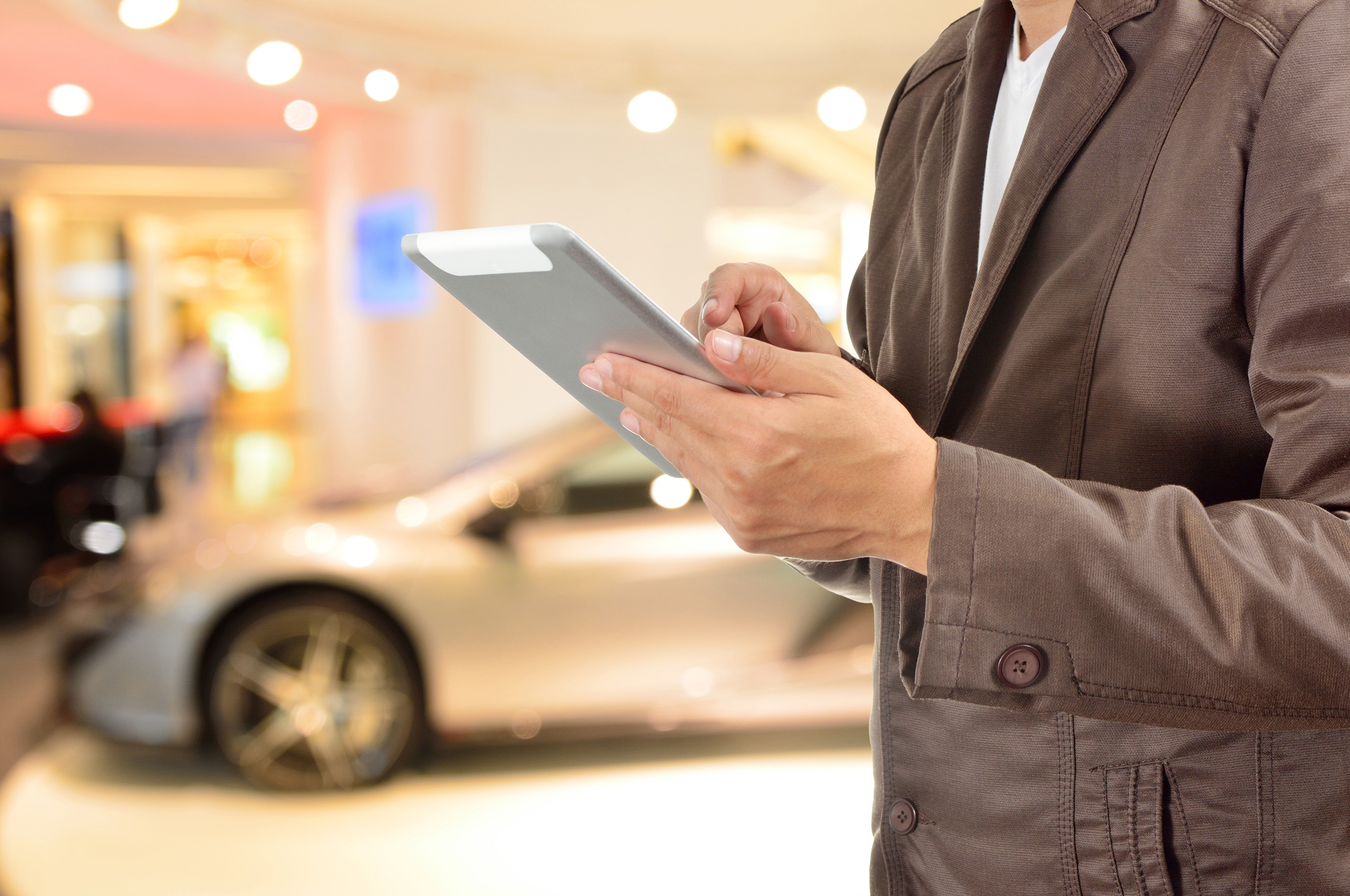 Young BusinessMan using Tablet device with Modern Sportcar
