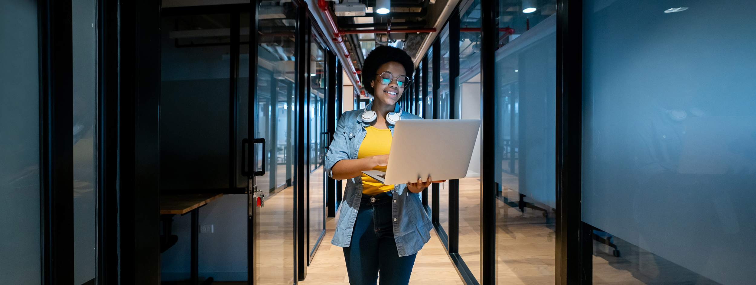 Happy IT technician working at the office using her laptop