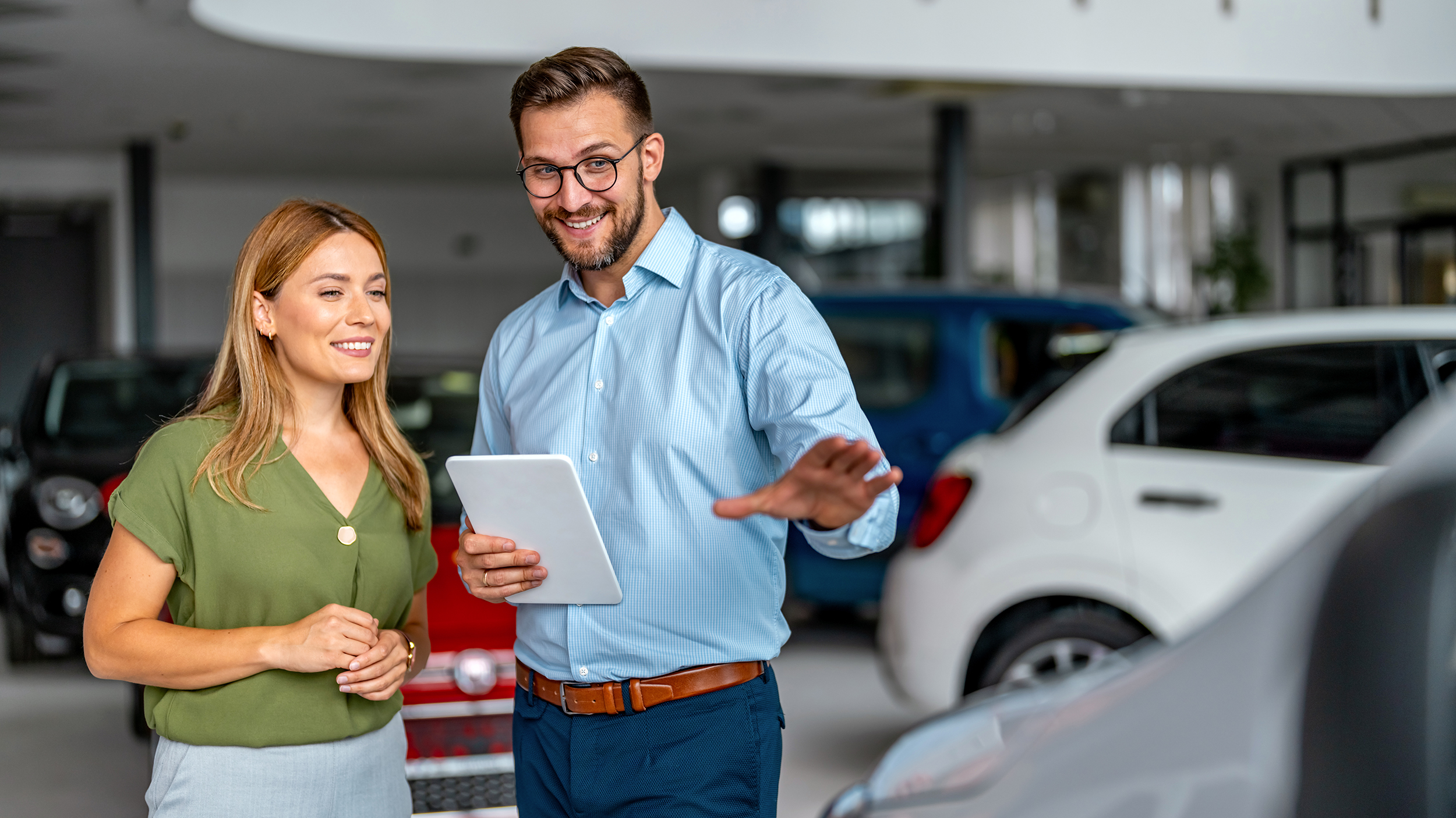 Salesman and a female customer in a car dealership