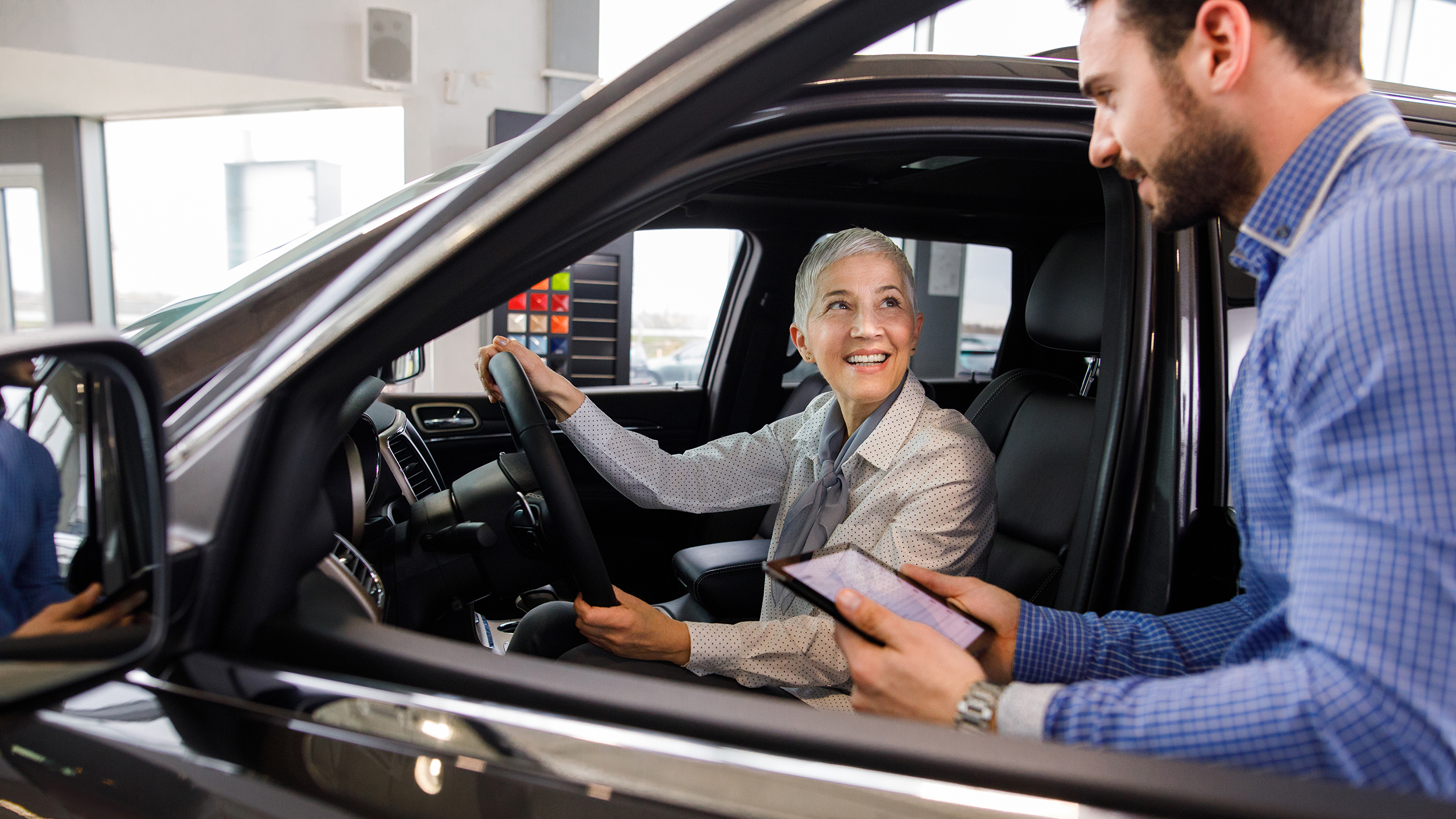 Salesperson showing vehicle to potential customer