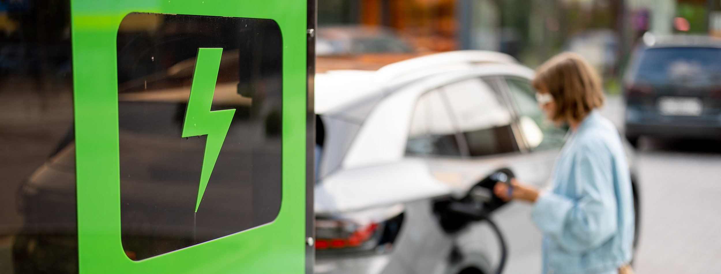 woman-charging-her-car-public-fast-charger
