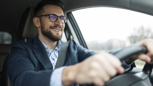 Smiling businessman driving his car