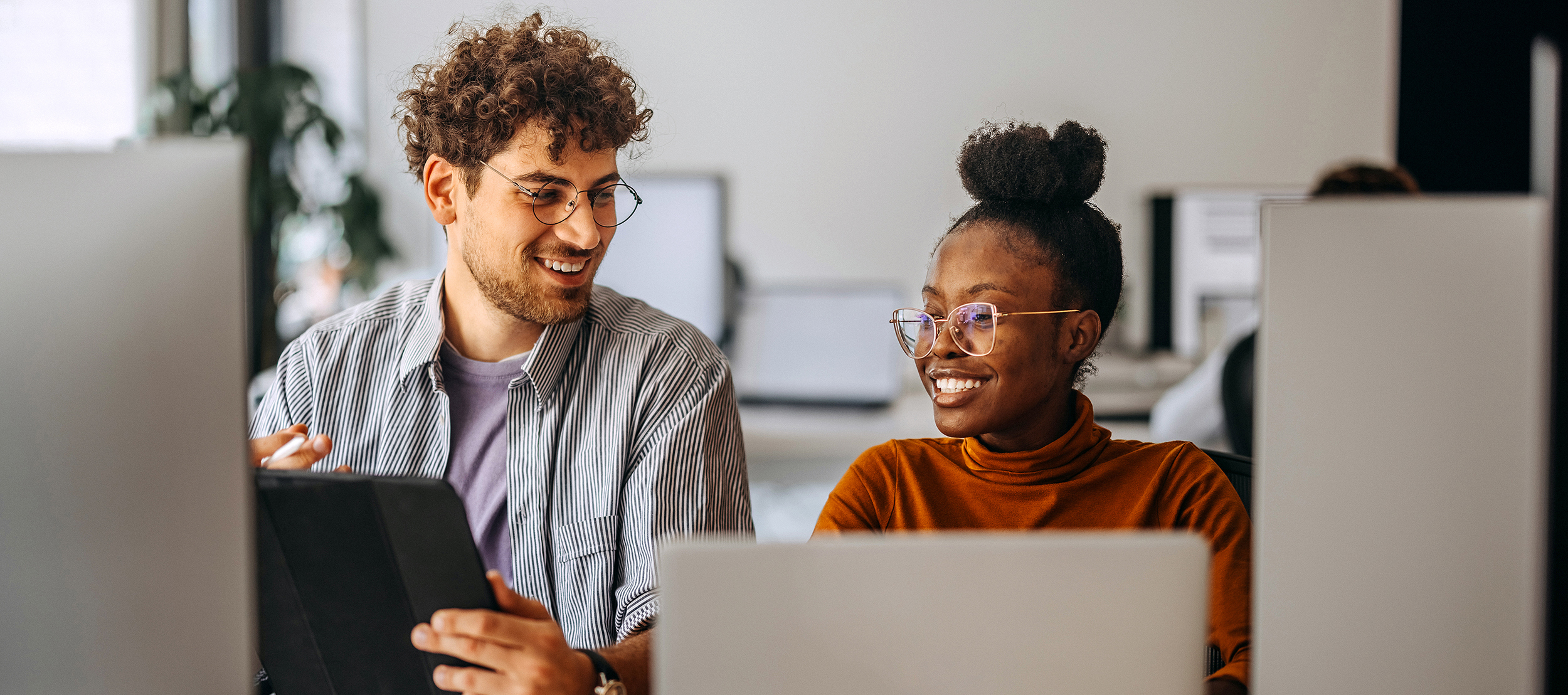 Two young colleagues working together at modern office