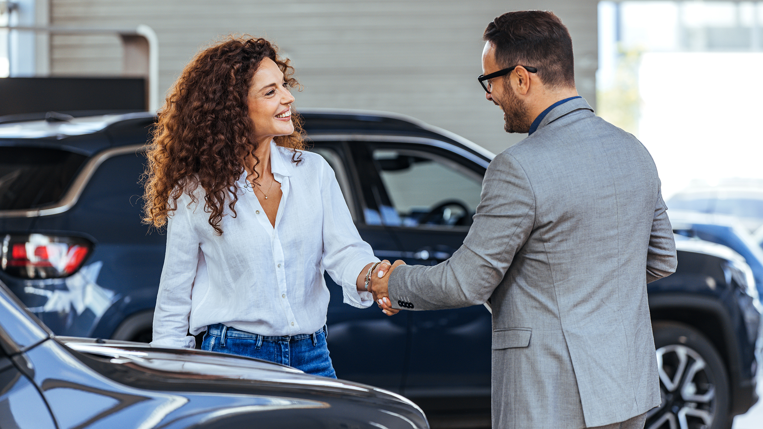 Woman in the showroom enjoying luxury car.