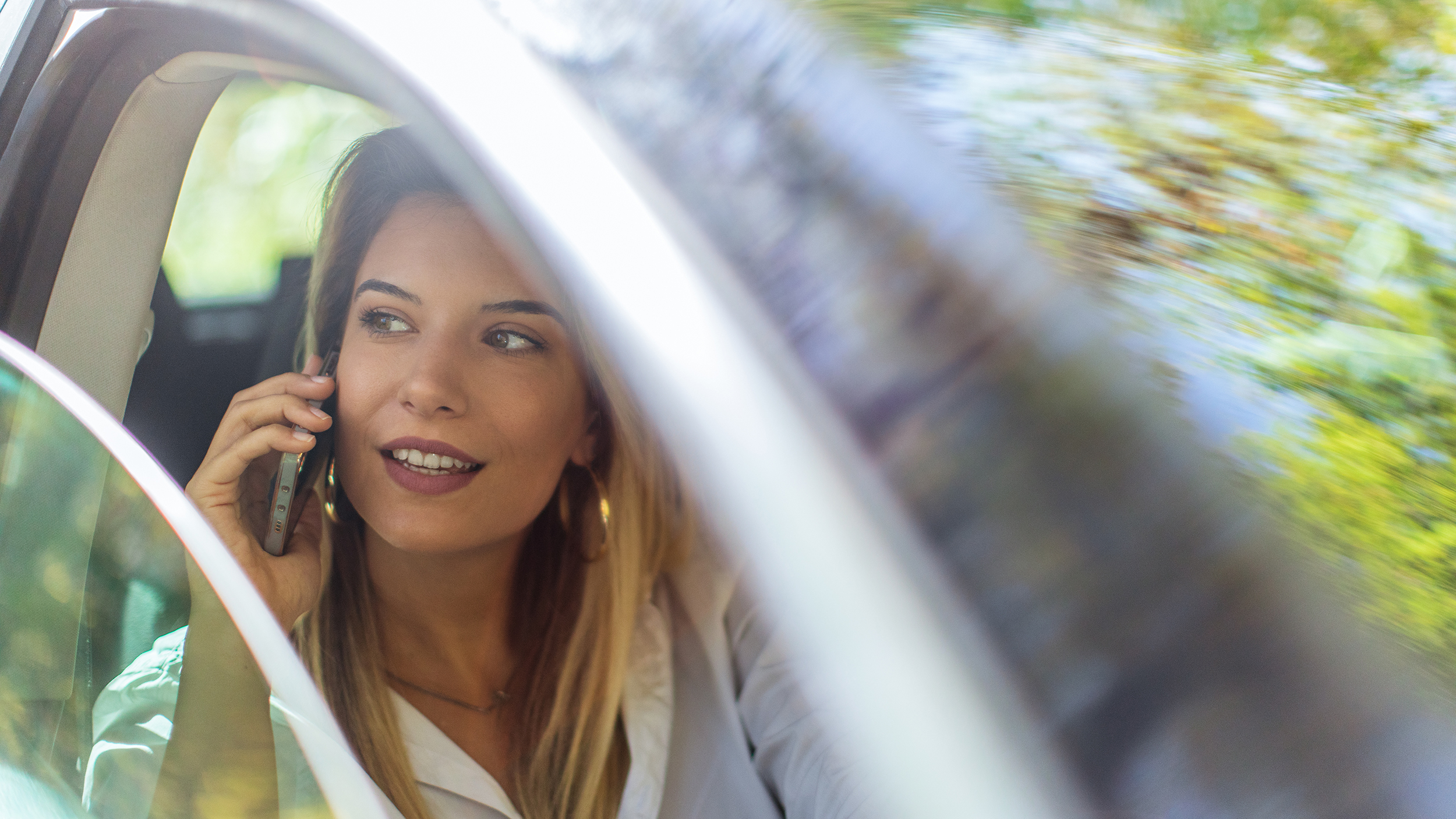 Young woman using mobile phone in car