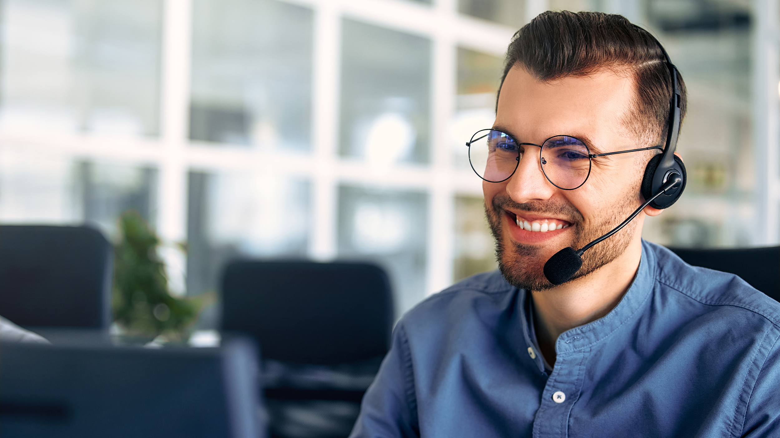 A call center worker sitting at a laptop in the office.