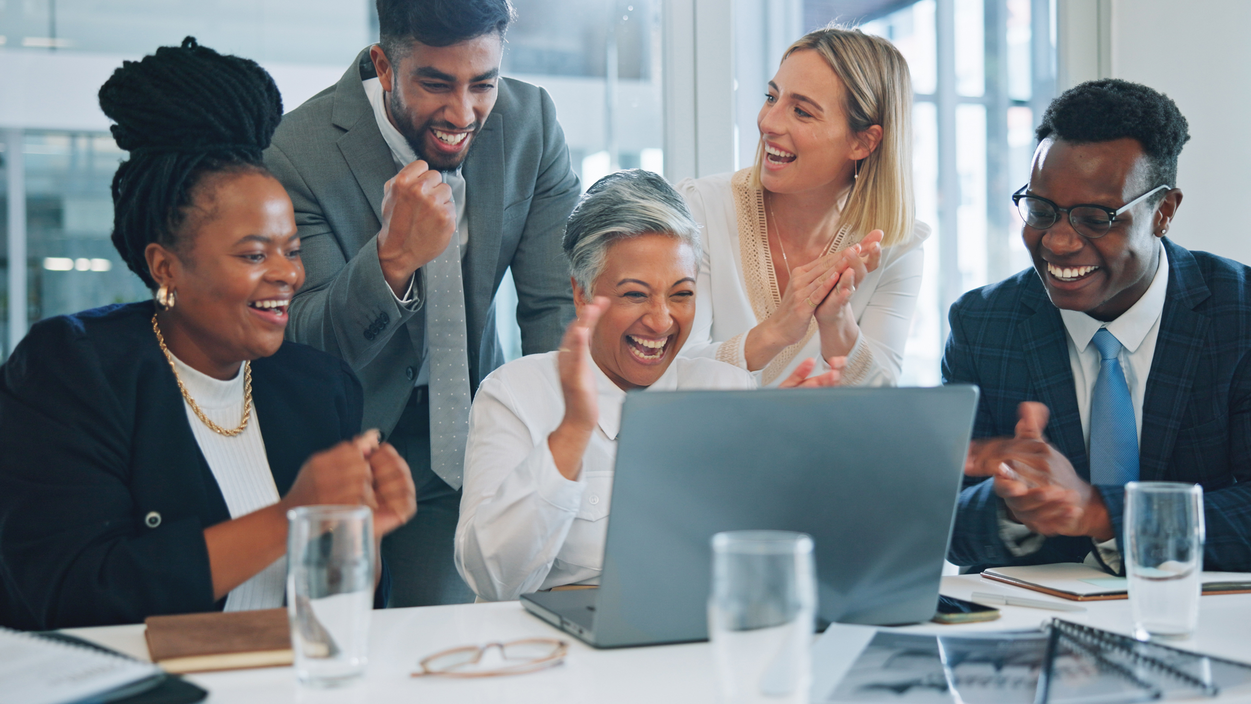 Laptop, business people and group celebrate, applause and cheers for project, revenue or achievement. Online statistics, data analytics and team clapping for success results, feedback report or news