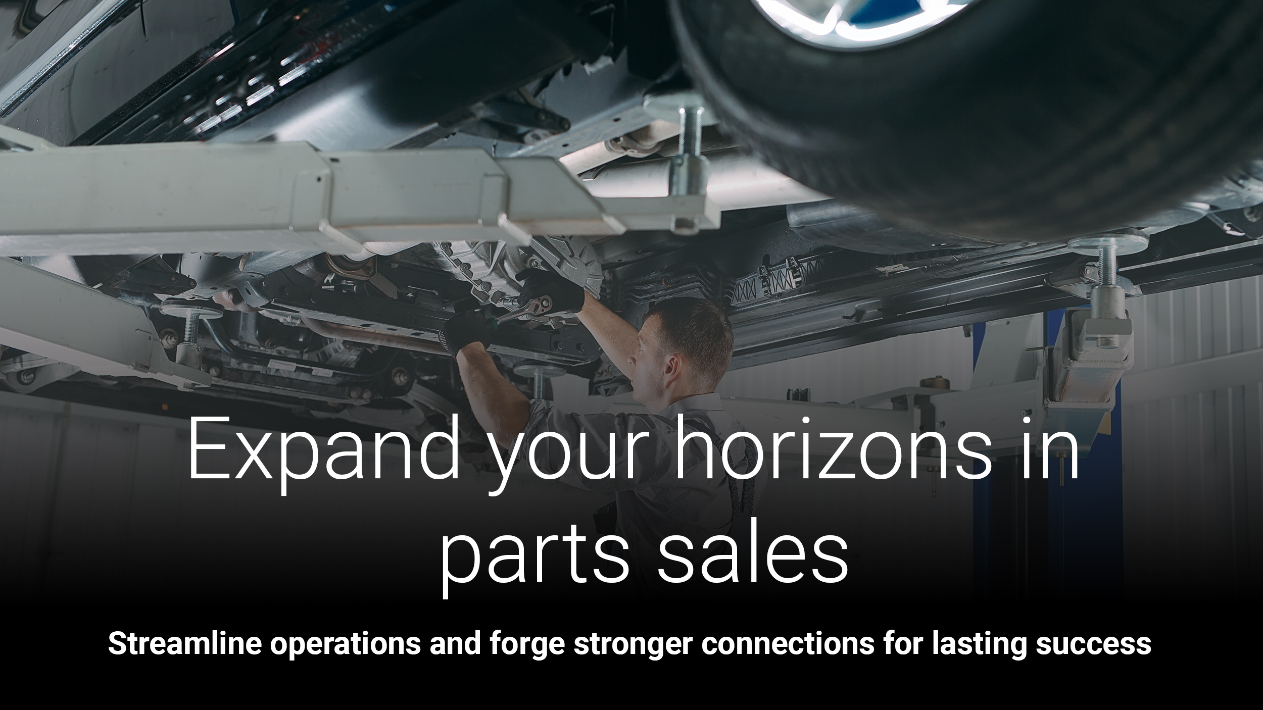 Portrait of a mechanic repairing a lifted car.